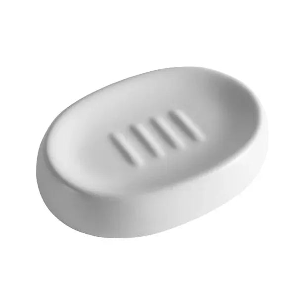 White ceramic soap dish with oval shape and three grooves