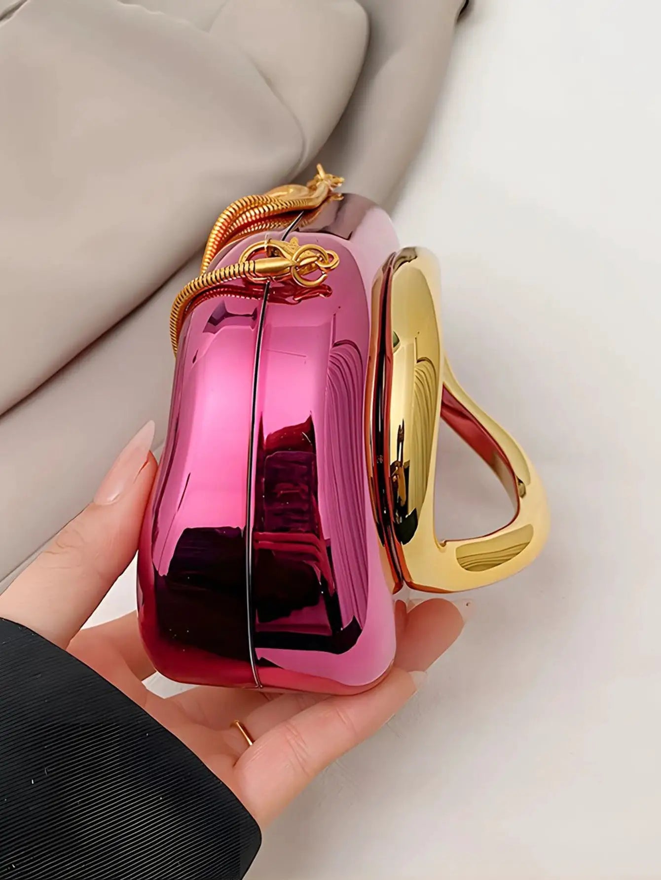 Acrylic magenta box-shaped crossbody bag with gold-tone hardware and chain strap