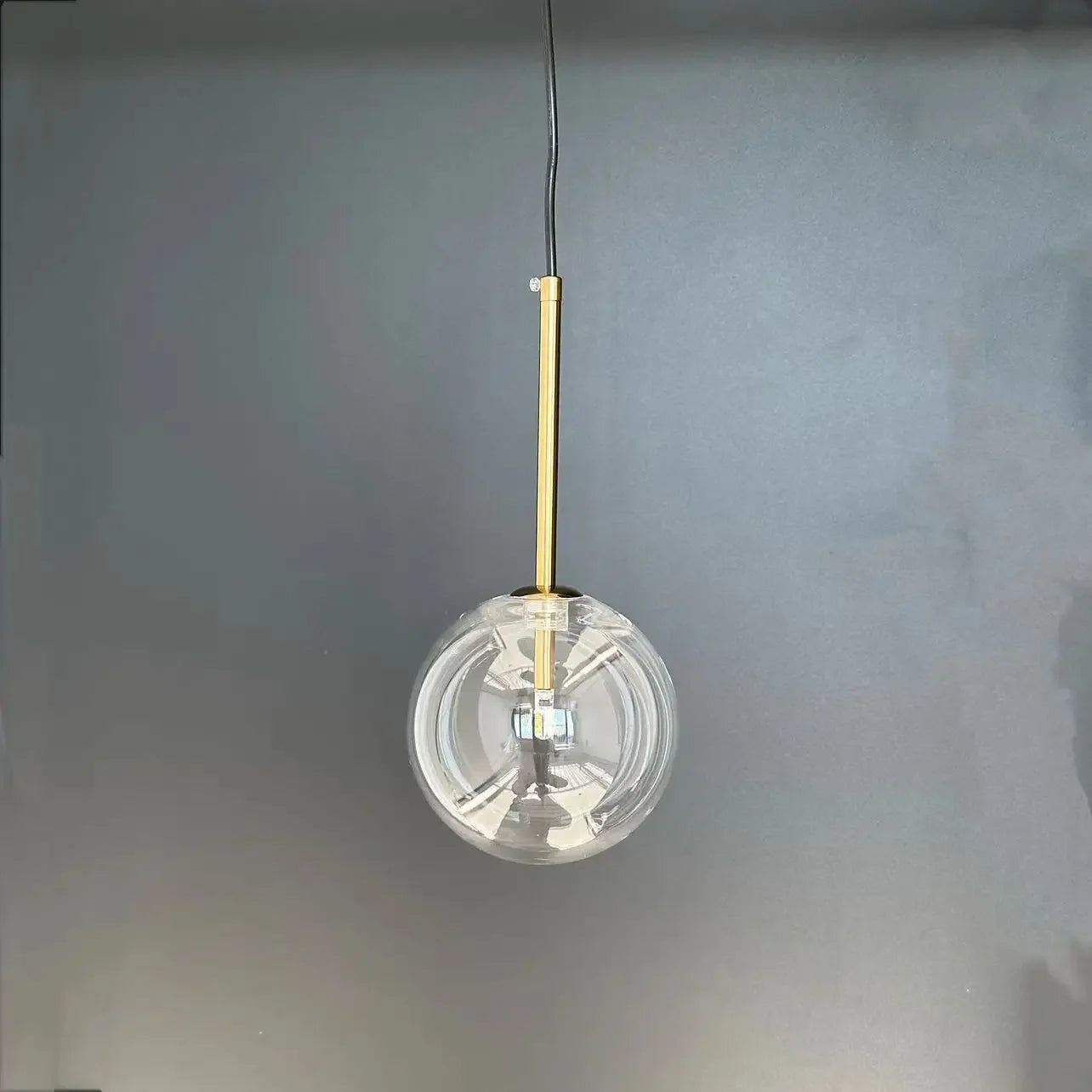Simples Market modern LED pendant lamp with a clear glass ball and gold hanging rod