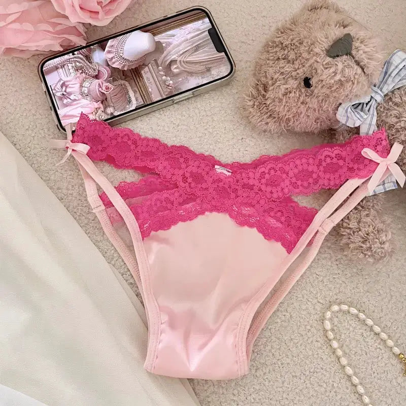 Pink lace-trimmed panties with satin front panel, low-rise cut, cross-strap side belts and bow accents