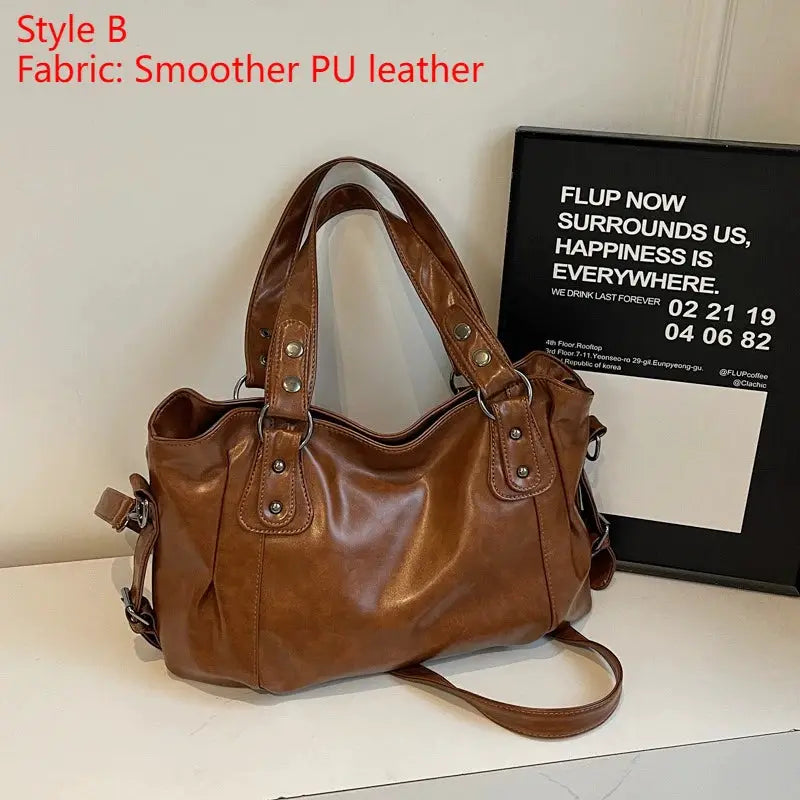 Shoulder bag in brown smooth PU leather with double handles and top zipper.