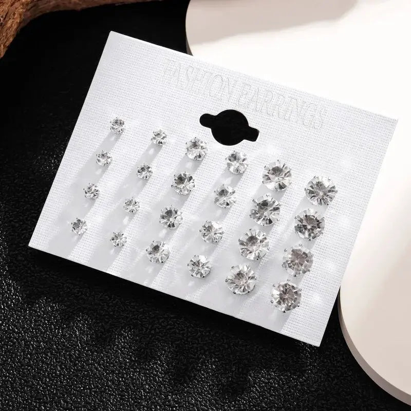 12-pair white crystal stud earrings set on display card; assorted sizes