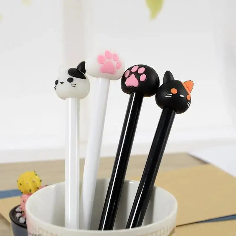 Kawaii cat gel pens with white and black bodies and cat-head toppers, 4 pens in cup.