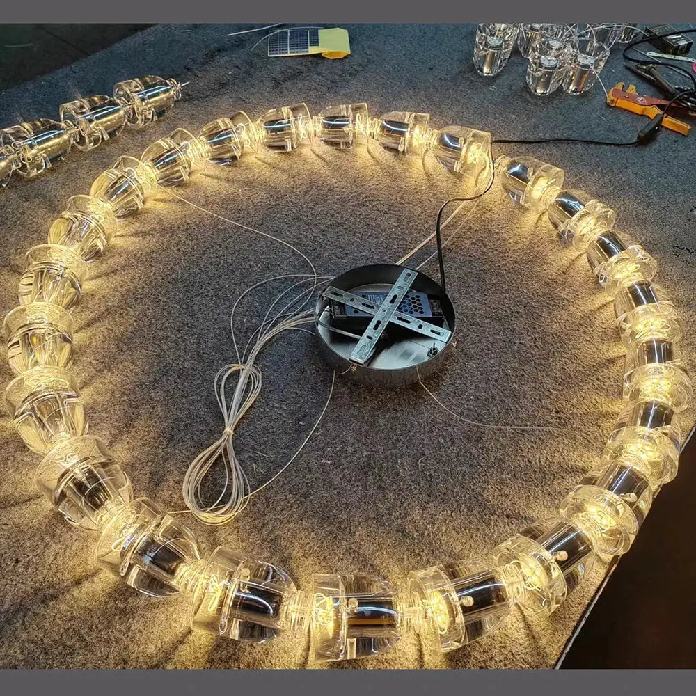 Necklace chandelier ceiling light with crystal acrylic beads arranged in a circular ring, warm amber glow