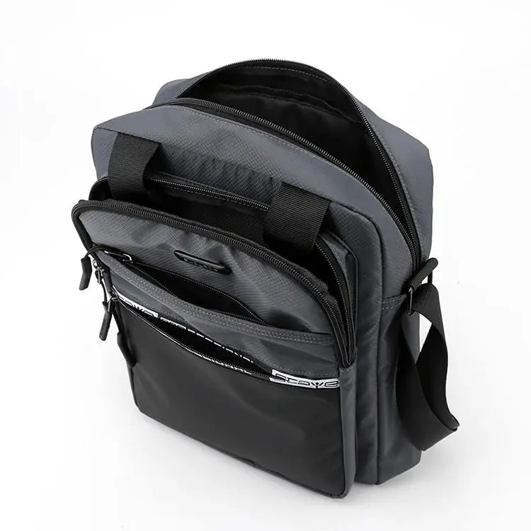 Men's crossbody bag by Simples Market in gray with an adjustable strap and multiple front pockets.