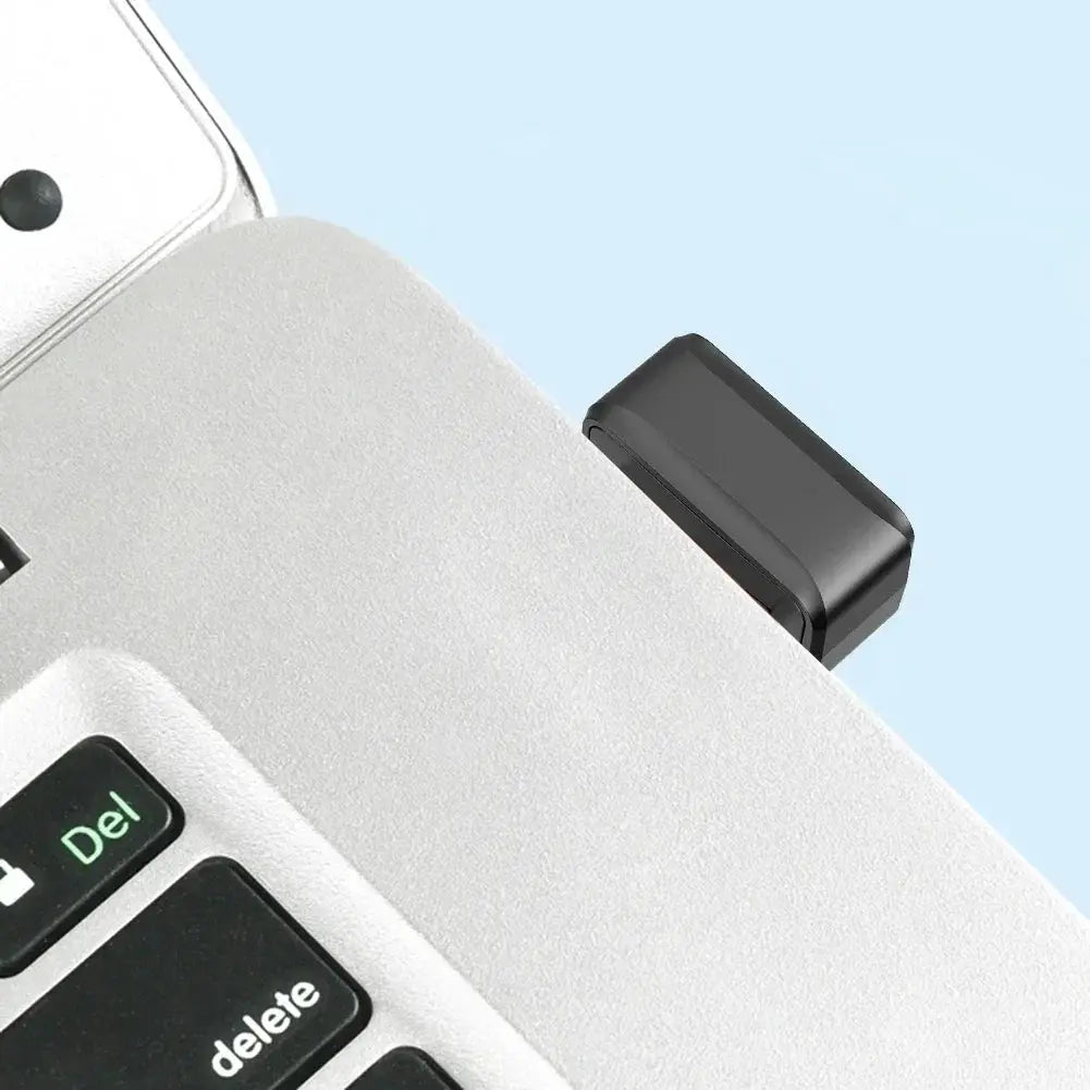USB fingerprint key reader, black biometric scanner plugged into a laptop USB port.