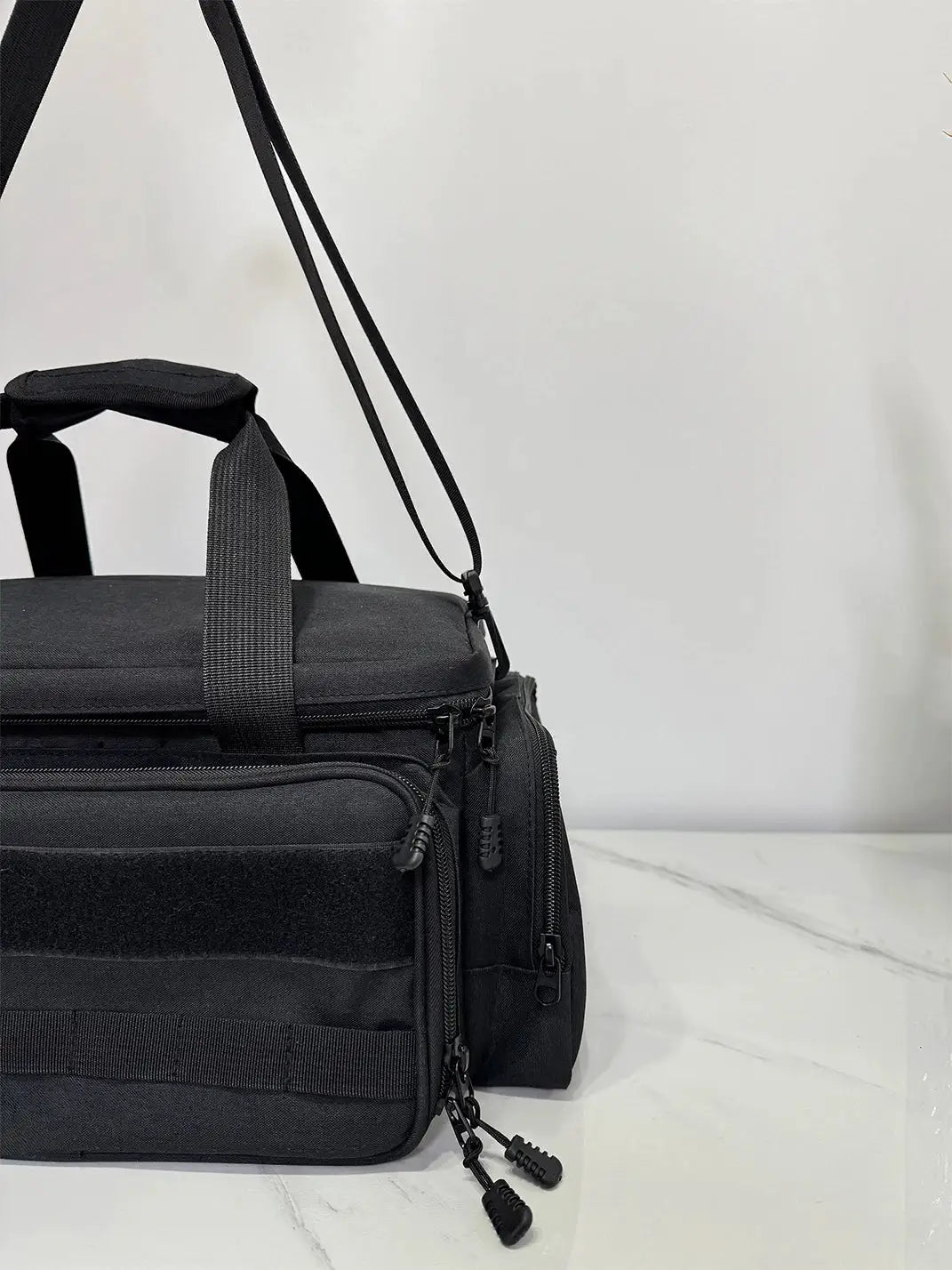 Black toolkit bag with shoulder strap and multiple zippered pockets