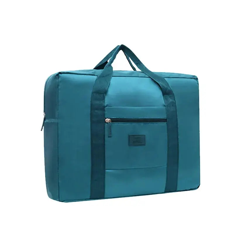 Foldable travel duffel bag in teal with front zip pocket and dual carry handles