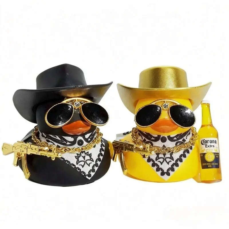 Two cowboy rubber duck car ornaments, black and yellow ducks with hats, sunglasses, bandanas, gold chains and guns.