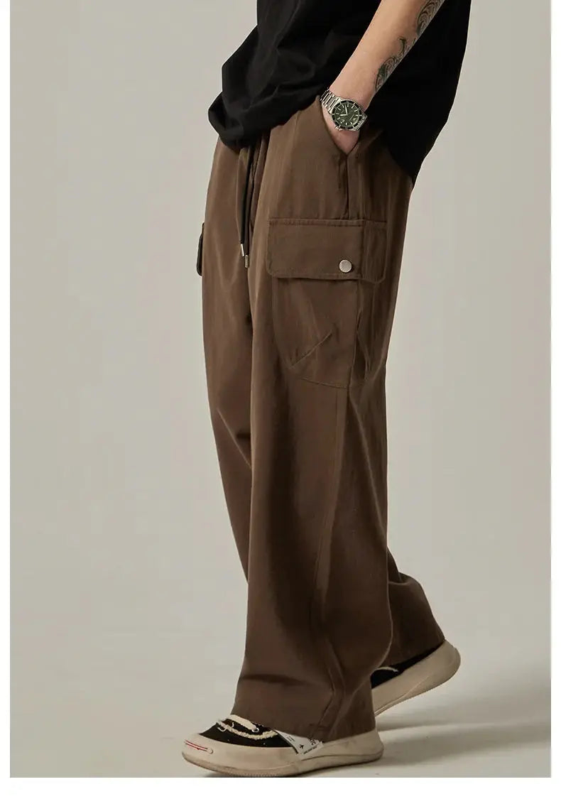 Men's brown cargo sweatpants with large flap pockets, drawstring waist, wide-leg fit.