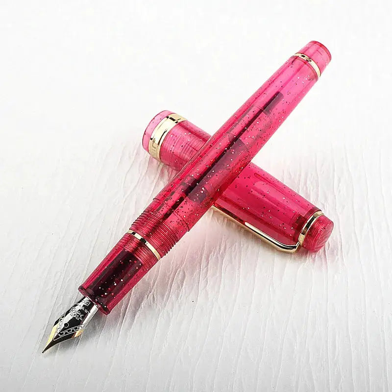 Two pink acrylic Jinhao 82 fountain pens with gold trim and a converter