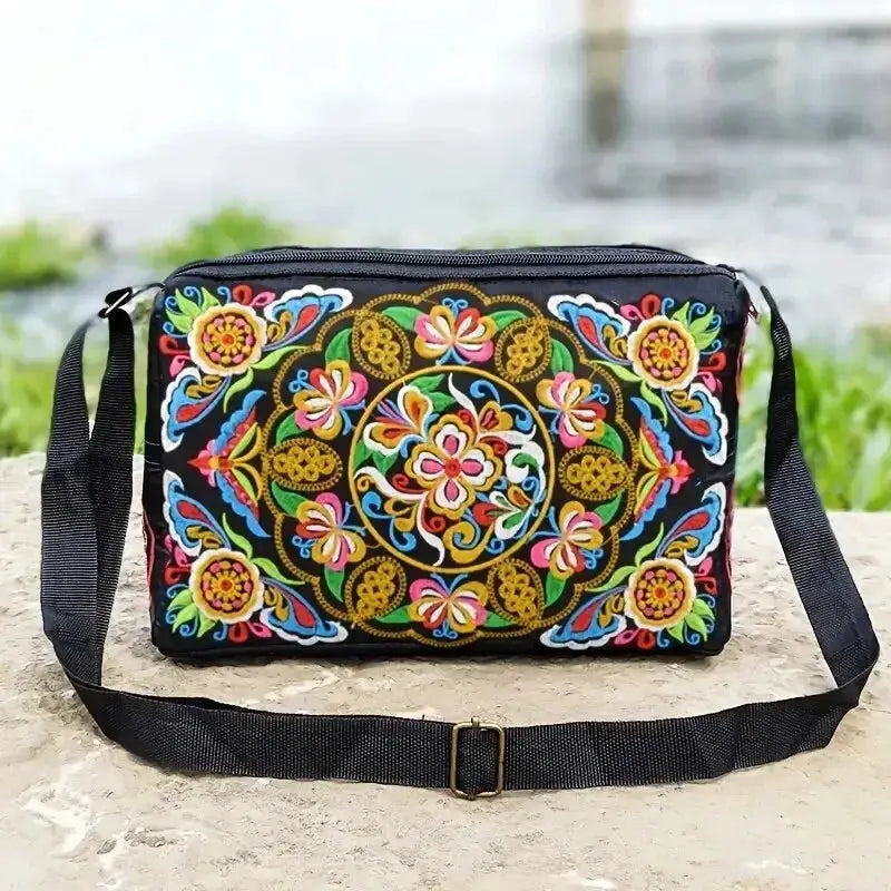 Nylon crossbody bag with colorful embroidered floral design on black background; adjustable strap