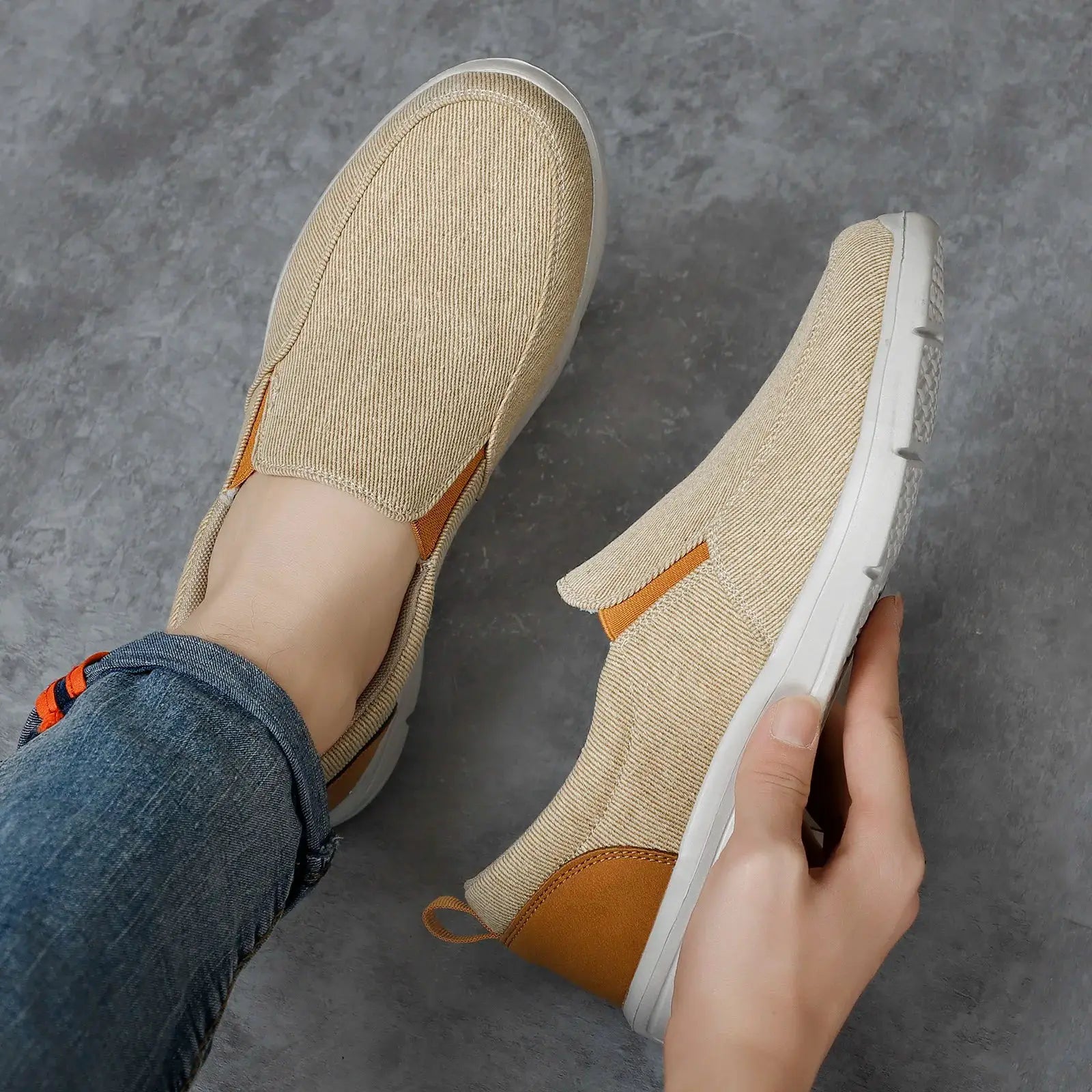 Men's beige canvas slip-on sneakers with white sole and orange heel accents