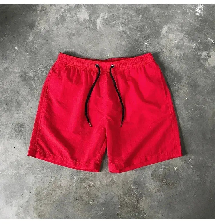 Men's red swim shorts with black drawstring and elastic waistband for beach and pool