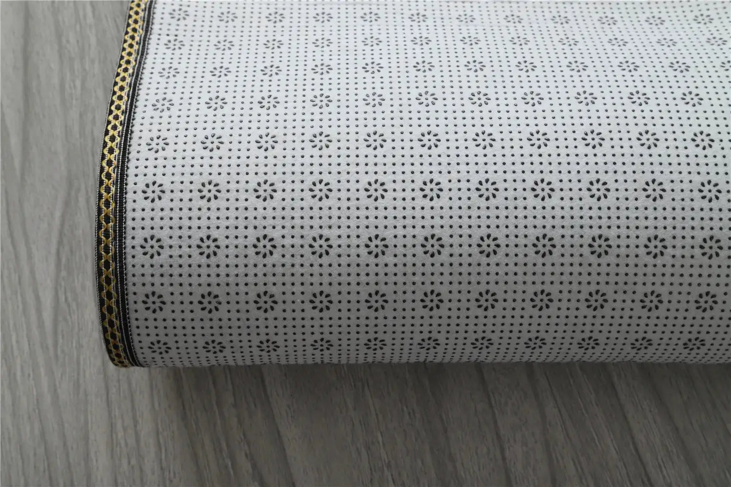 Premium Fluffy Area Rug by Simples Market, rolled white rug with dotted floral pattern and black-gold edge trim.