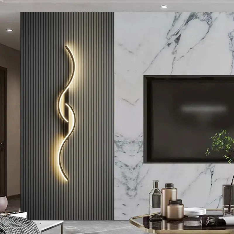 Modern LED wall lamp with a curved wavy light strip on a dark ribbed wall panel beside a marble feature wall.