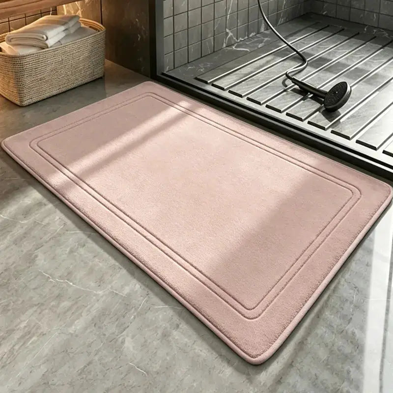 Pink bathroom rug mat beside a glass shower enclosure; soft, quick-drying, absorbent bath mat.