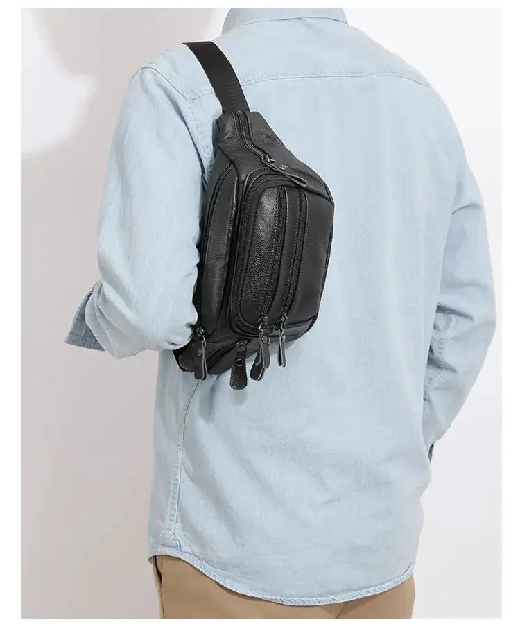 Men's black genuine leather fanny bag with multiple zipper pockets, worn crossbody.