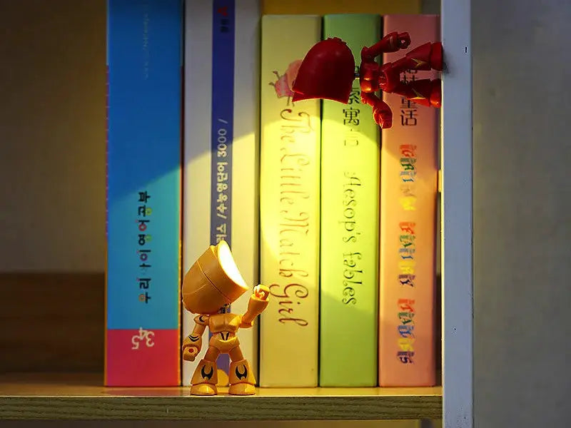 Mini night light LED cartoon hero police desk lamp in red on a shelf beside colorful books