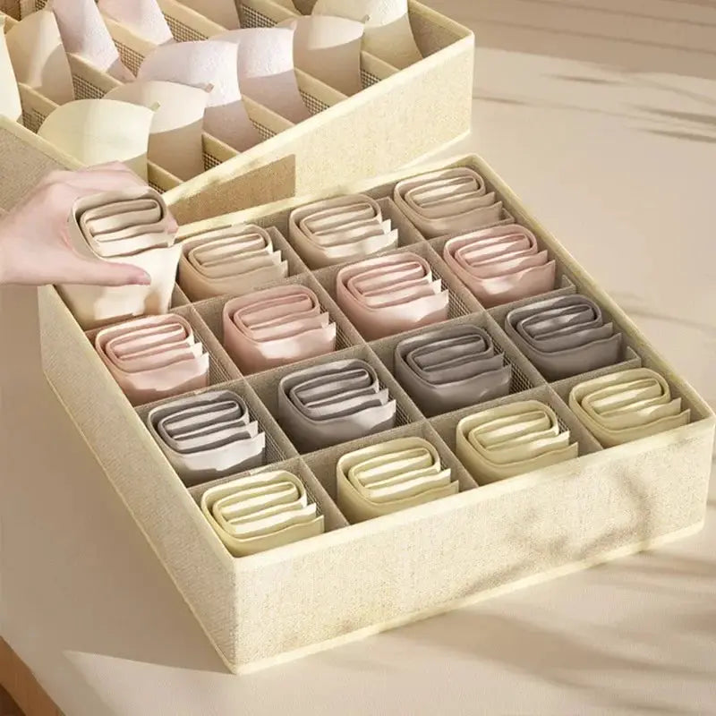 Underwear organizer storage box with 16 grid compartments; pastel folded garments in beige, pink, and gray