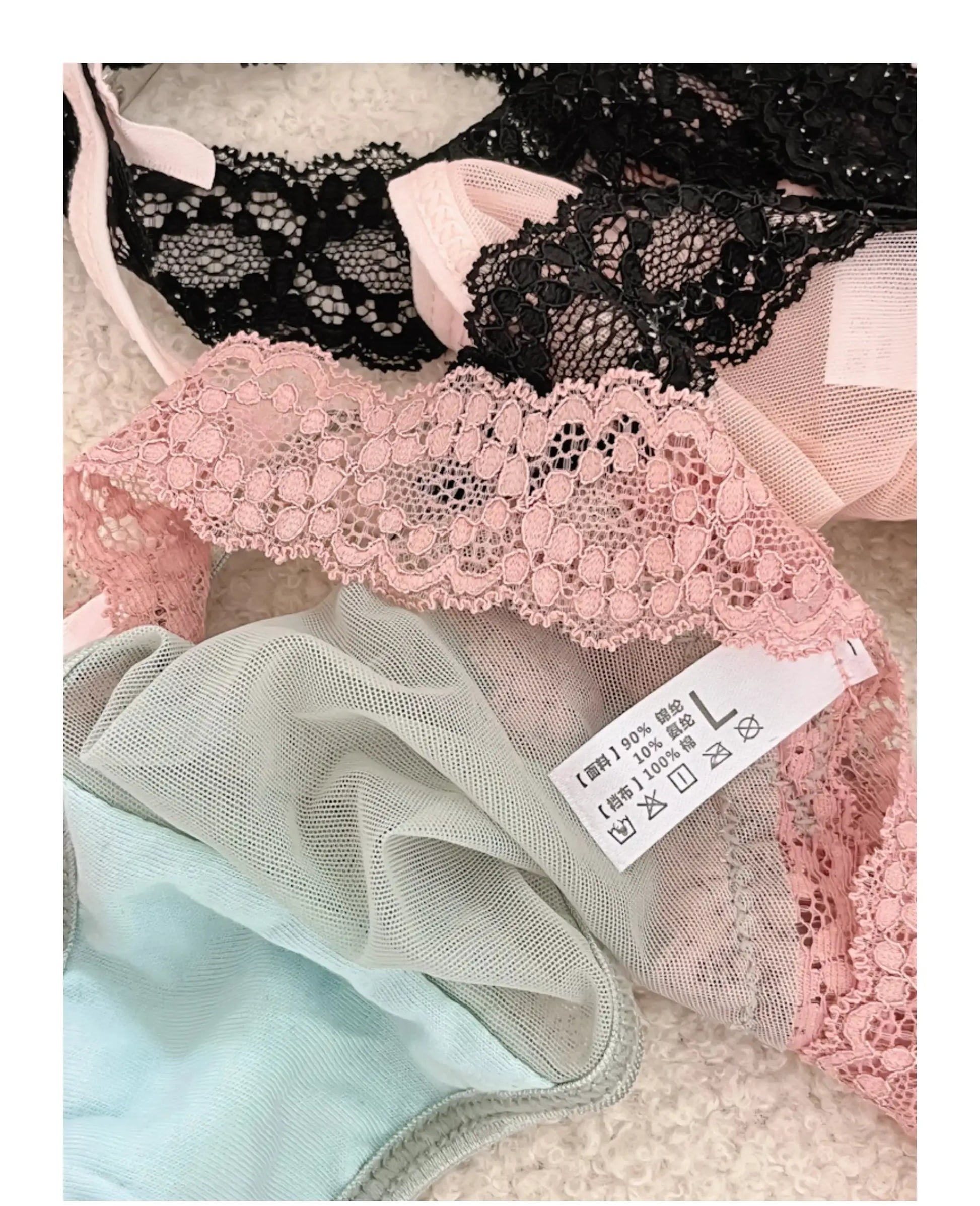 Two-piece lace lingerie set in pink and black with floral patterns and sheer mesh panels