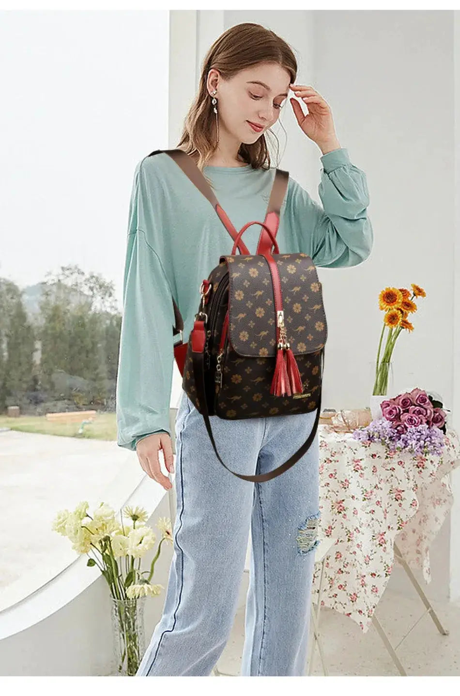Ladies leather backpack with brown floral print, red tassel accents, large capacity.