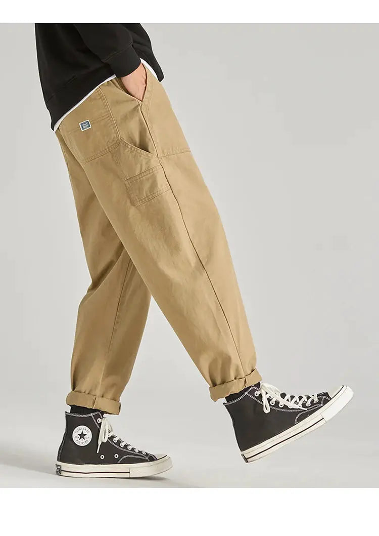 HIQOR men's beige cargo pants with multiple pockets and cuffed hems, paired with black Converse high-tops.