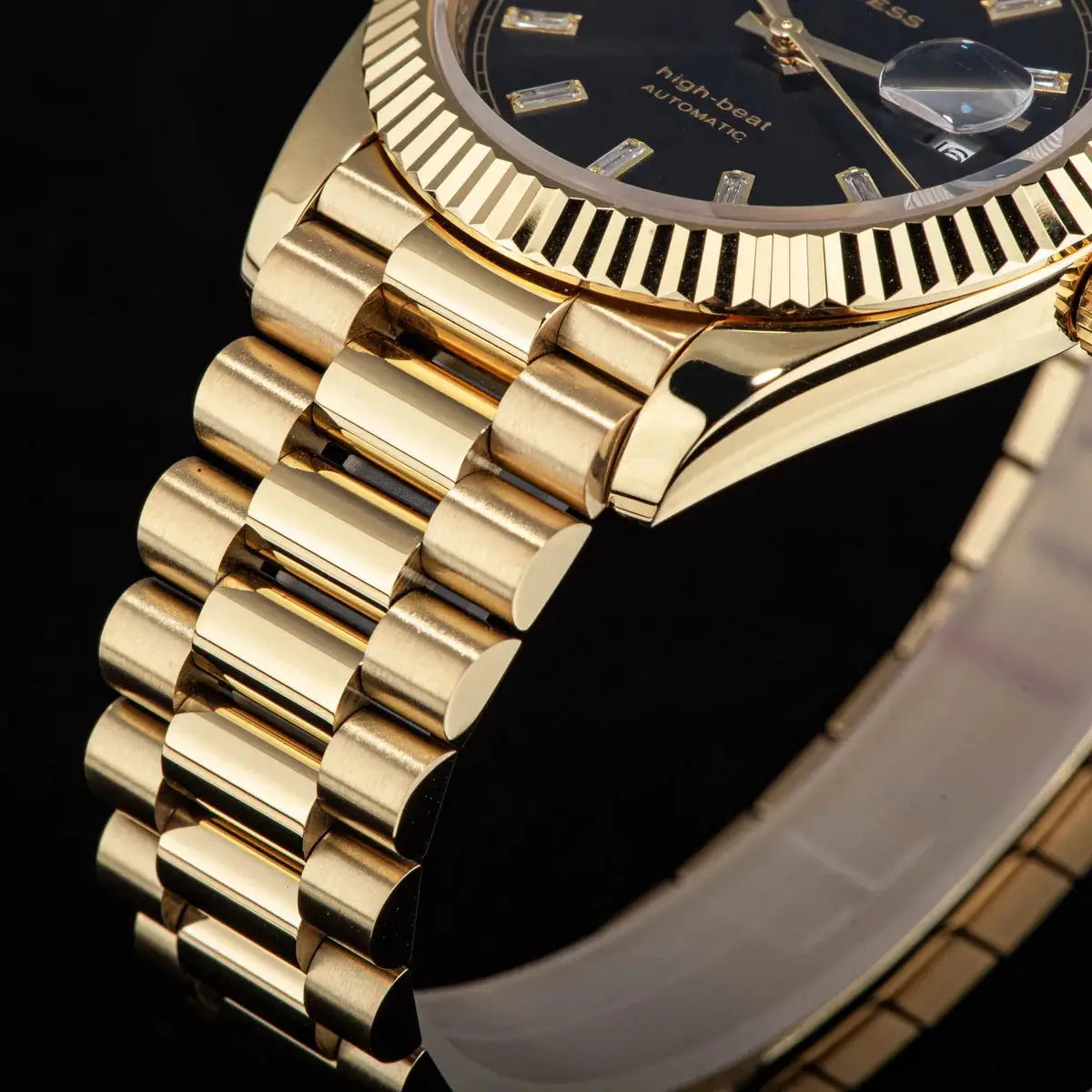 Sugess gold-tone men's wristwatch with fluted bezel, black dial, date magnifier, sapphire glass, gold bracelet
