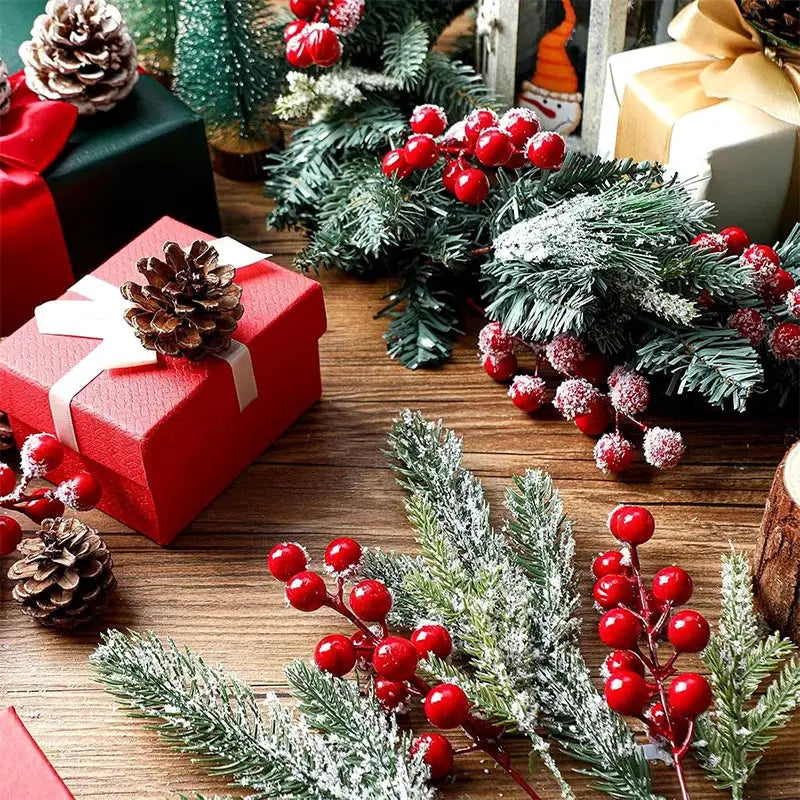 Artificial pine needle branch with red holly berries, snow-dusted for Christmas decor