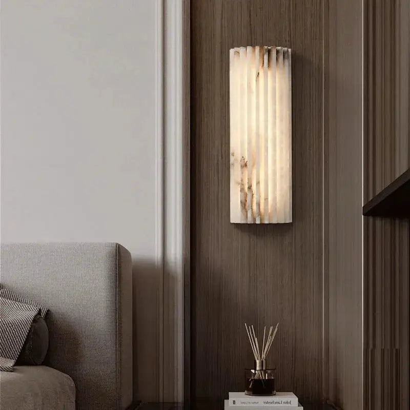Modern minimalist marble wall lamp sconce mounted on dark wood wall with warm bedside glow