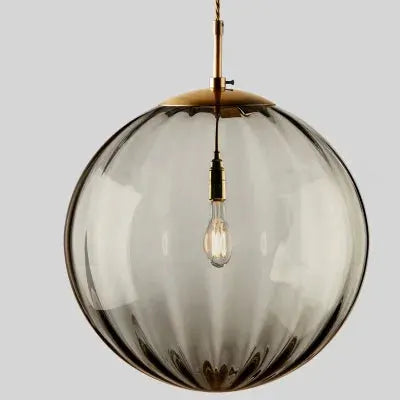 Modern LED pendant light by Simples Market, clear ribbed glass sphere with brass accents