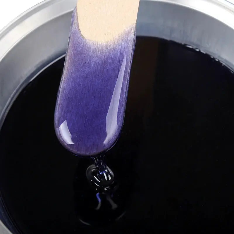 Simples Market depilatory wax beans, purple hard wax in a pot with wooden spatula.