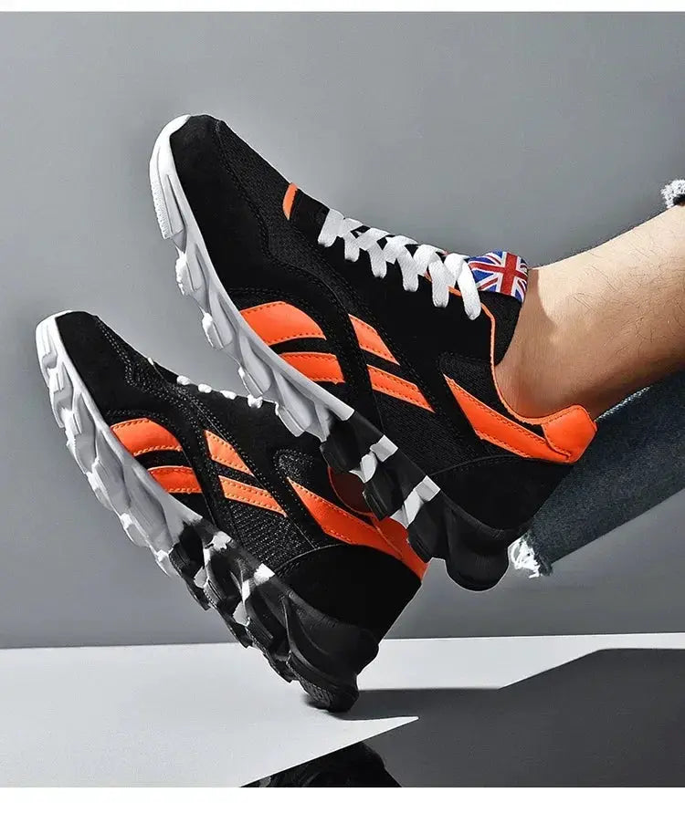 Pair of men's running sneakers in black and orange with white laces, chunky white soles, Union Jack detail