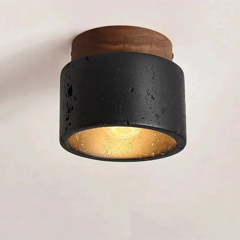 Wabi-sabi black cylindrical ceiling lamp with cave-stone texture and warm gold interior light