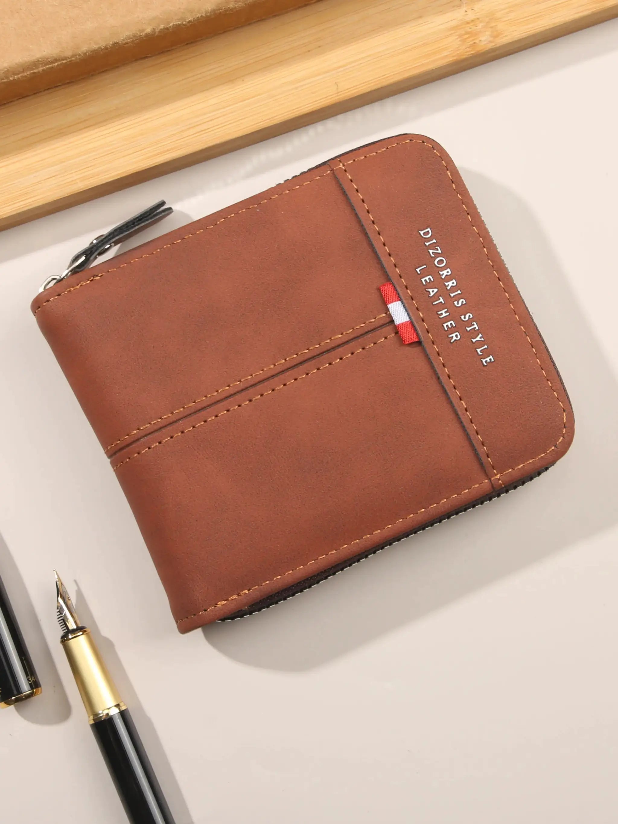 Brown leather wallet with zip closure, compact square design, yellow stitching and small red-white-blue tag