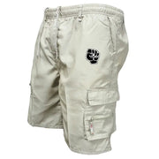 Simples Market men's khaki cotton cargo shorts with multi-pocket design, drawstring waist, and a black patch logo.
