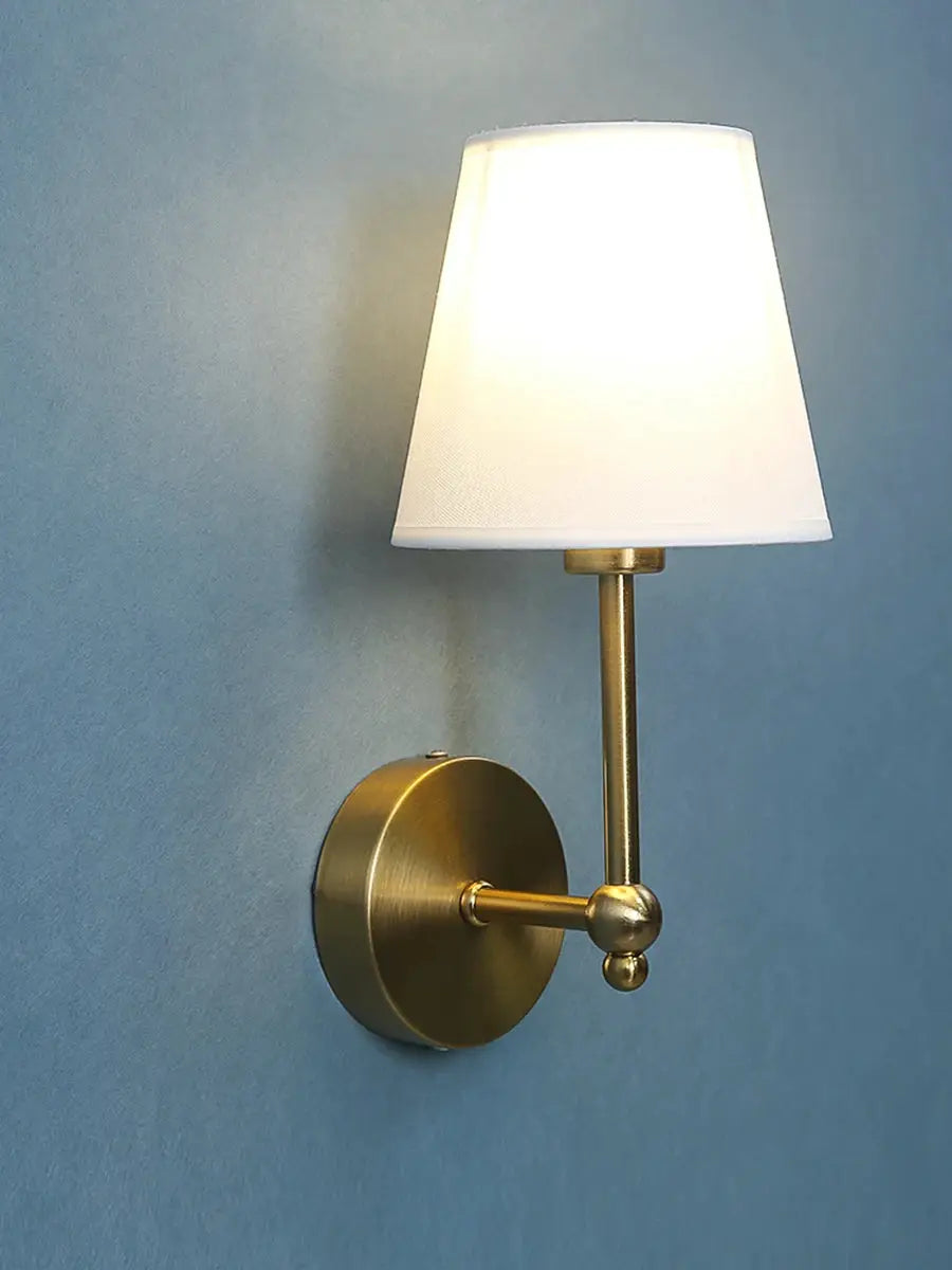 Brass wall lamp sconce with white fabric shade; vintage retro style for bedroom or bathroom.