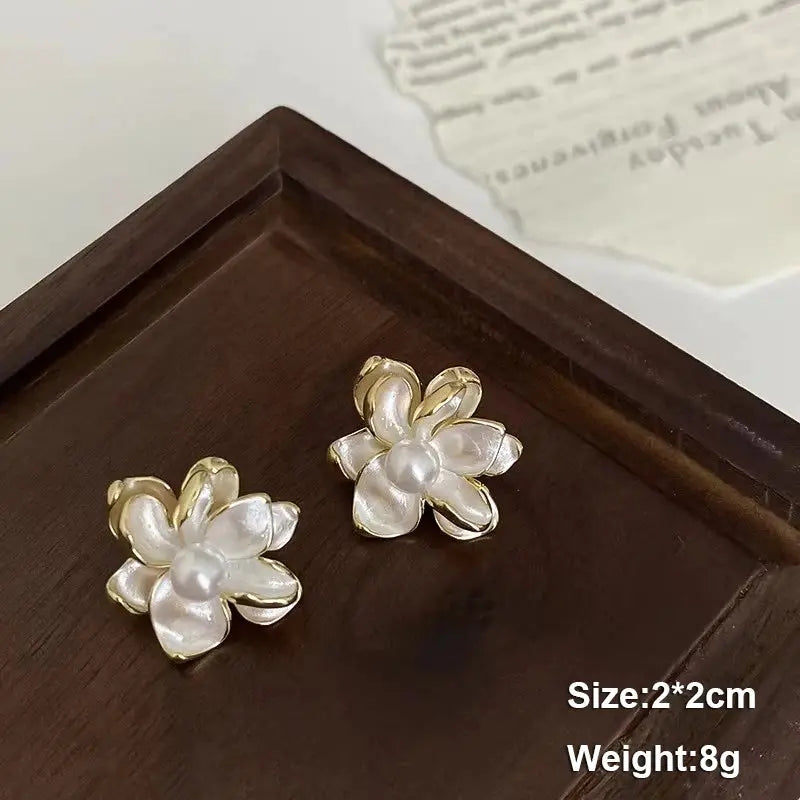 Flower stud earrings, white petals with pearl centers and gold-tone trim; pair