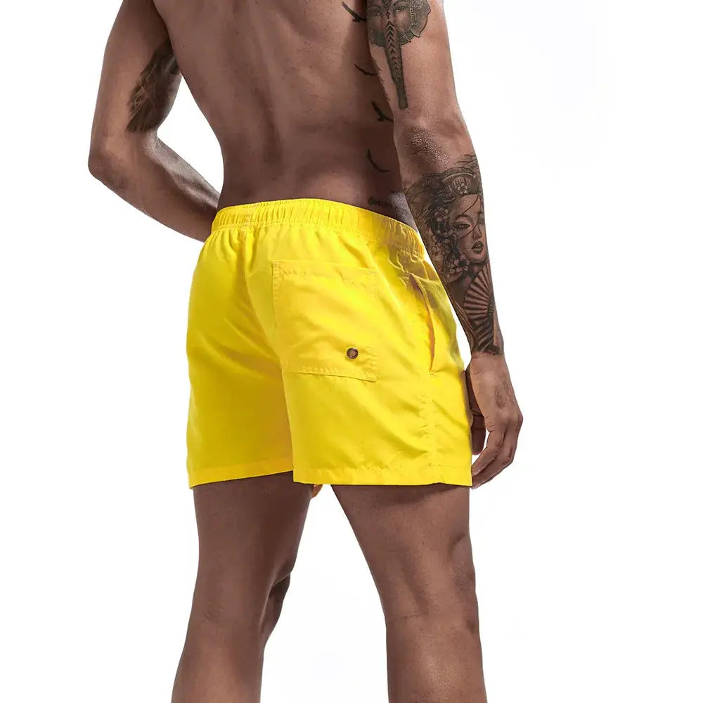 Swim trunks for men by Simples Market, yellow quick-dry fabric with back pocket and elastic waistband.