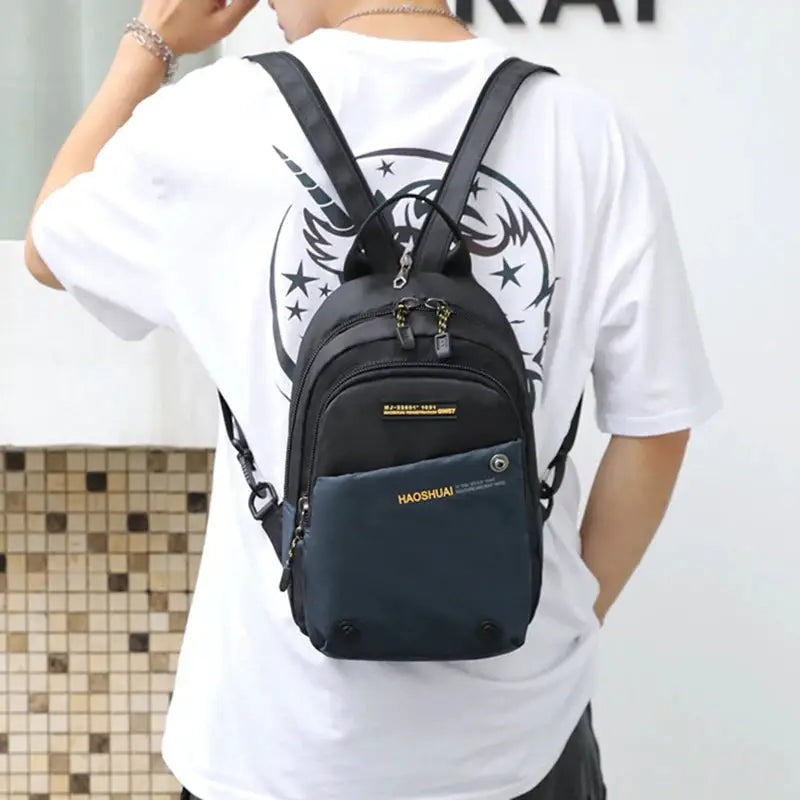 Simples Market men's small nylon backpack with black body and blue front pocket, multiple compartments