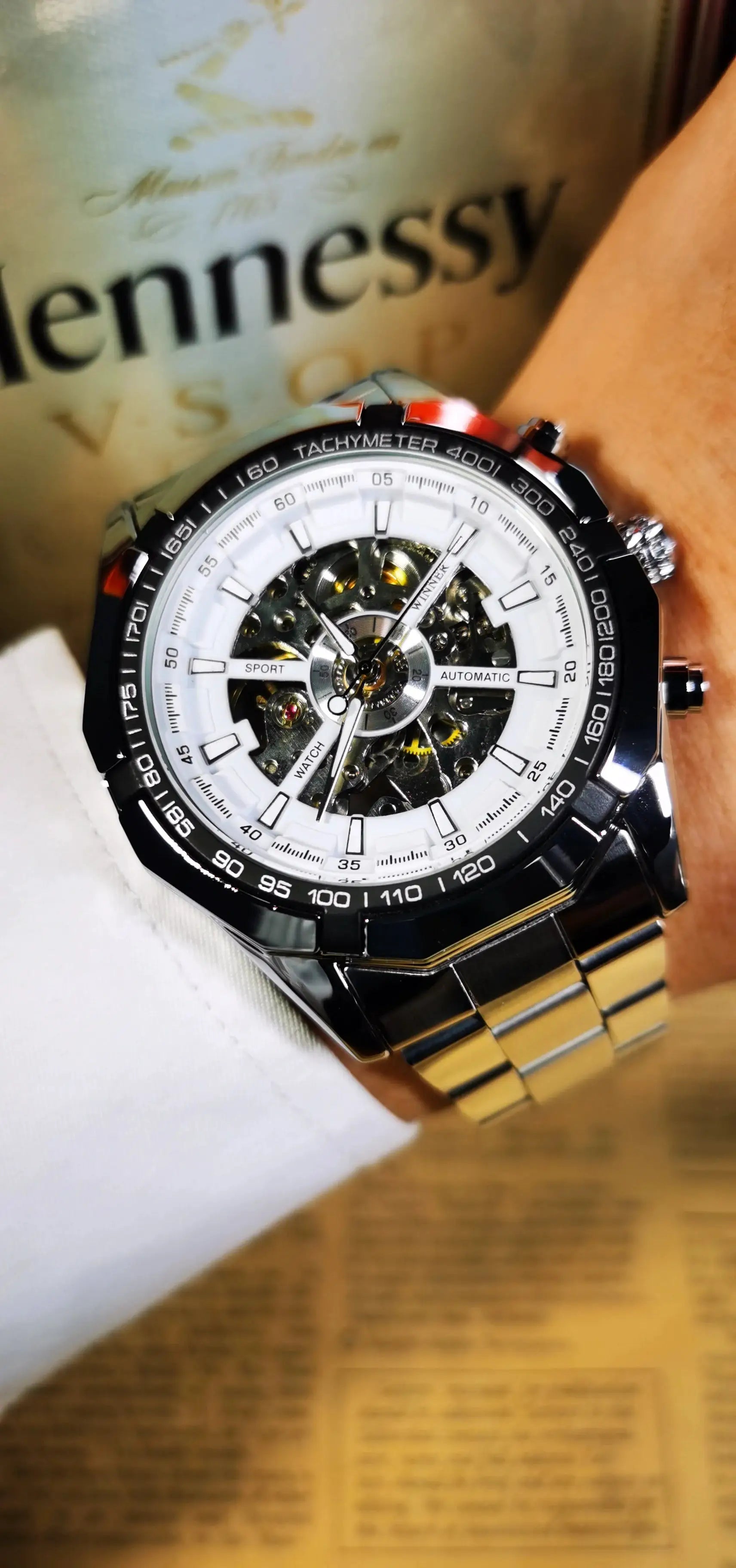 Winner men's skeleton watch with stainless steel bracelet, white dial, and luminous hands.