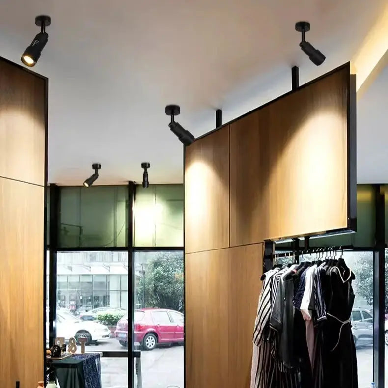 Adjustable LED ceiling spotlight by Simples Market; black, surface-mounted 7W zoomable beam 5°–60°, group of fixtures.