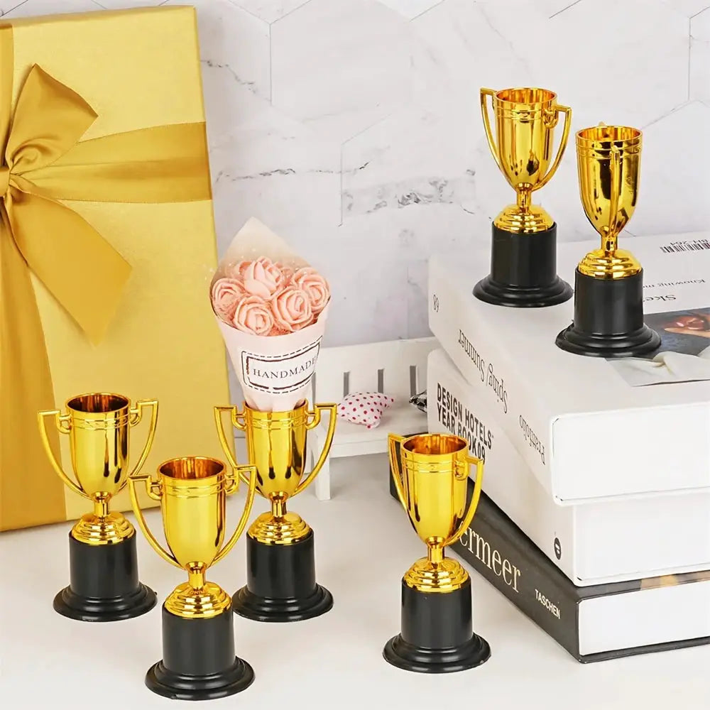 Plastic gold trophy prizes for kids’ parties; 6/12pc set with black bases
