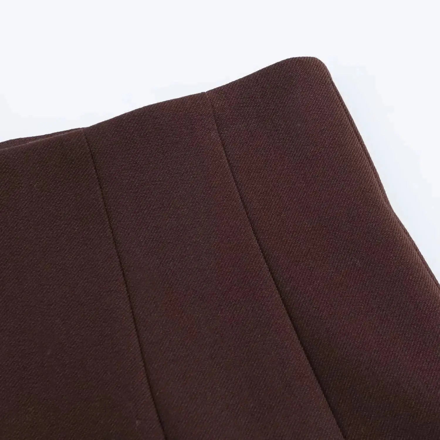 Brown blazer fabric close-up with textured weave and seam details