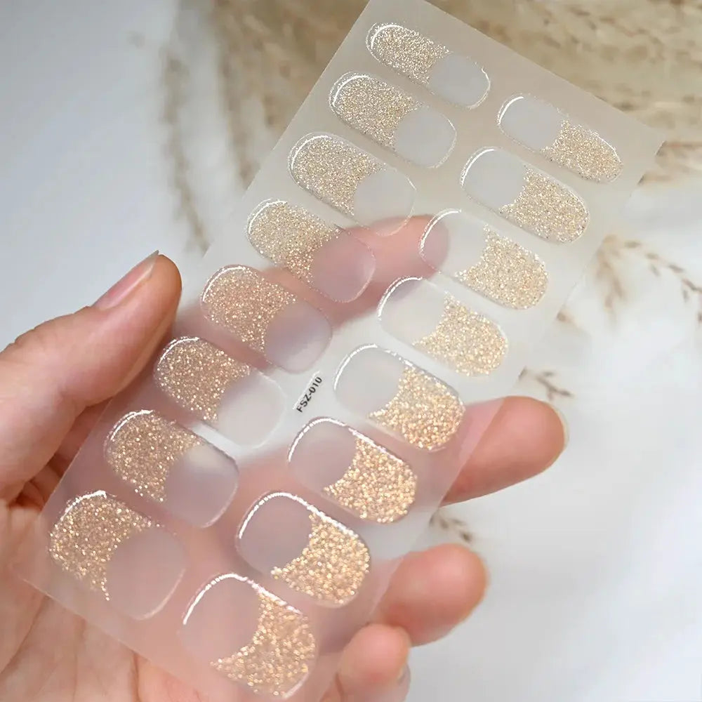 Nail sticker sheet with 16 nude French tips featuring gold glitter accents for full-coverage UV gel nails