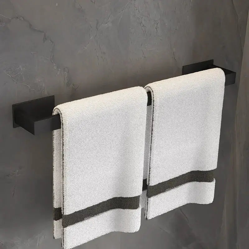 Black bathroom towel bar set with dual rails mounted on a dark wall, holding two white towels.