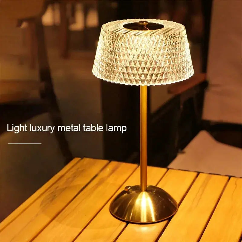 Rechargeable LED night lamp with brass metal stem and diamond-pattern glass shade on a wooden table