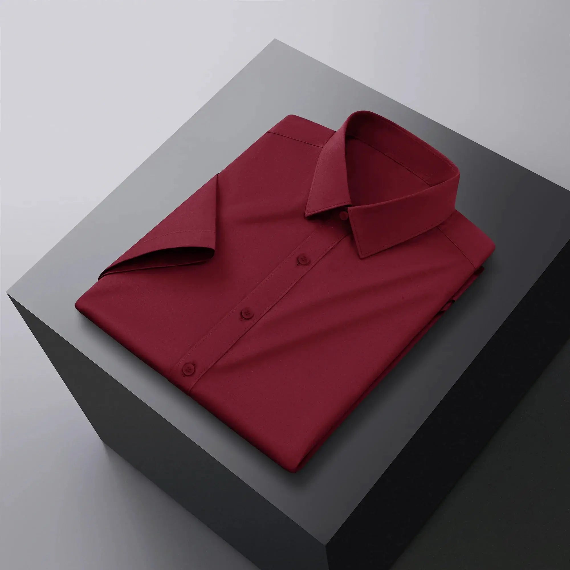 Men's burgundy solid short-sleeve button-up shirt folded for a business-casual look.