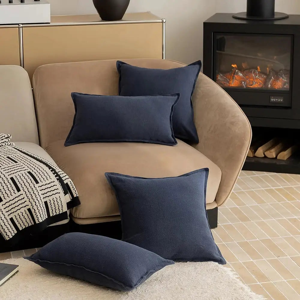 Simples Market navy ramie cushion covers; multiple dark blue pillows on beige sofa with a geometric throw.