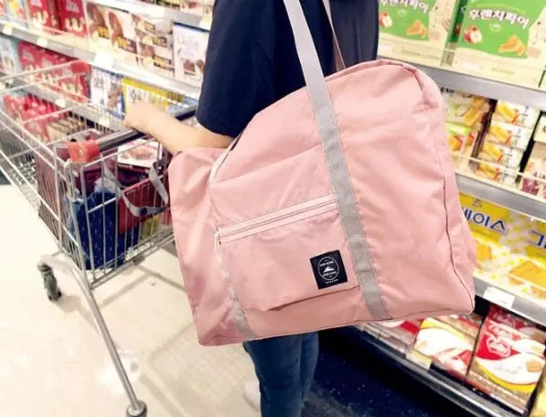 Travel bag by Simples Market in pink with gray handles and front zip pocket